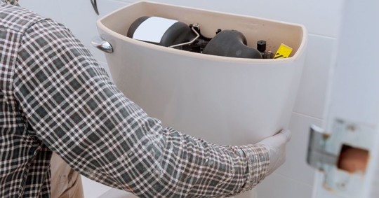 man fixing toilet