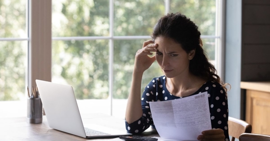 woman looking at high utility bill