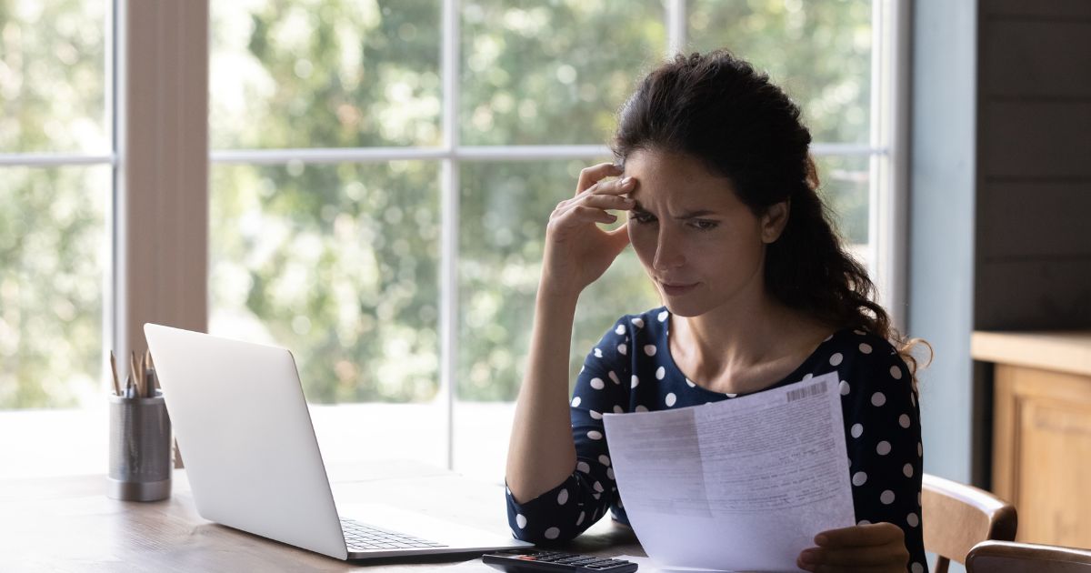 woman looking at high utility bill