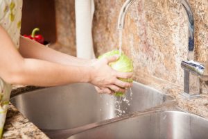 Sink basin kitchen with woman washing lettuce