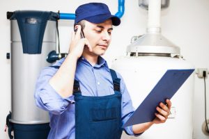 Water heater technician looking at a piece of paper and making a phone call